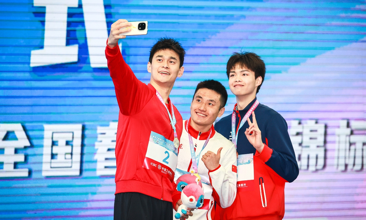 Chinese swimmer Sun Yang (left) poses for a selfie on the podium after taking the silver in the men's 400 meters freestyle at the national spring swimming championships in Qingdao, East China's Shandong Province, on March 19, 2025. Three-time Olympic champion Sun, who returned to competition in 2024 after serving a four-year ban due to a controversial anti-doping rule violation, headlines as the eldest participant in the event. Photo: VCG