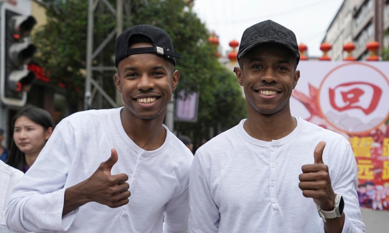 A pair of twins from Chad are pictured during the 19th Mojiang international twins festival in Mojiang Hani Autonomous County, southwest China's Yunnan province, May 1, 2025. Over 1,000 multiple births from around the world took part in a parade during the twins festival in Mojiang Hani Autonomous County on Thursday. (Xinhua/Chen Xinbo)